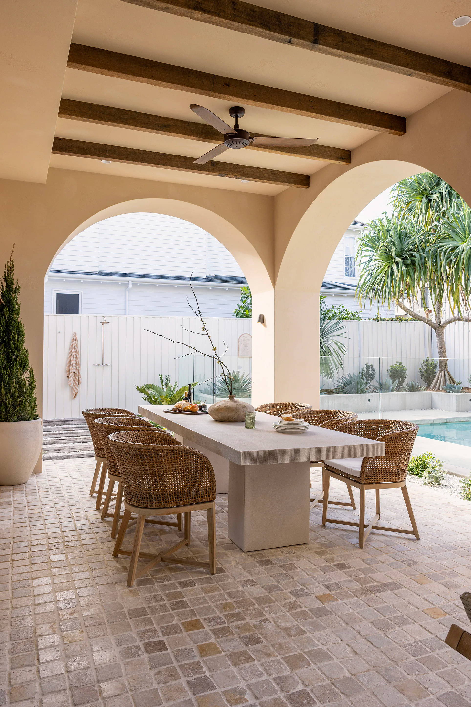 Outdoor dining area with a table, chairs, and pool view.