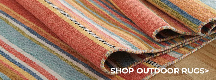 Cushions and striped outdoor rugs displayed for shopping.