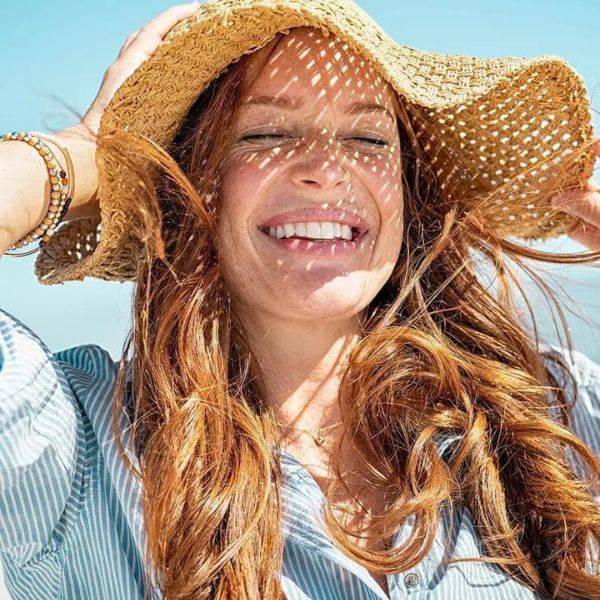 Model wearing sun hat - ARK Skincare expert guide on how to look after your skin during the summer