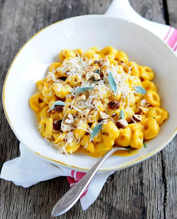 Tortellini pasta in a creamy butternut squash sauce topped with grated cheese and served in a bowl