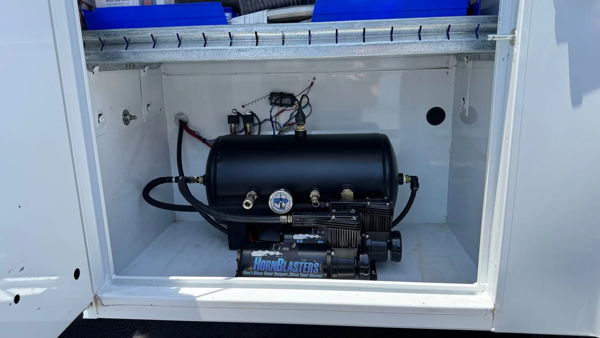 Black air tank and compressor mounted inside a side service compartment on George's 2022 Chevrolet Silverado 3500 HD, install photo 3