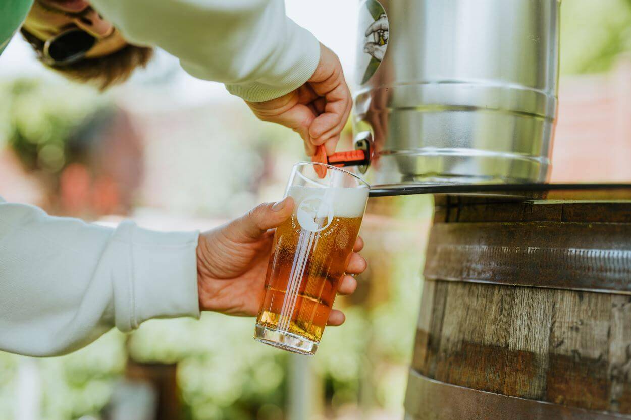 A man pours a mini keg of Small Beer IPA