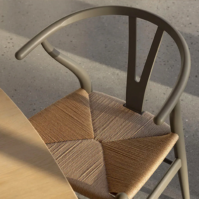 Wooden chair with woven seat beside a round table.