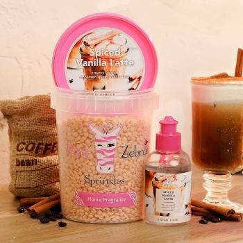 Container of vanilla latte-scented product with a drink and coffee beans.