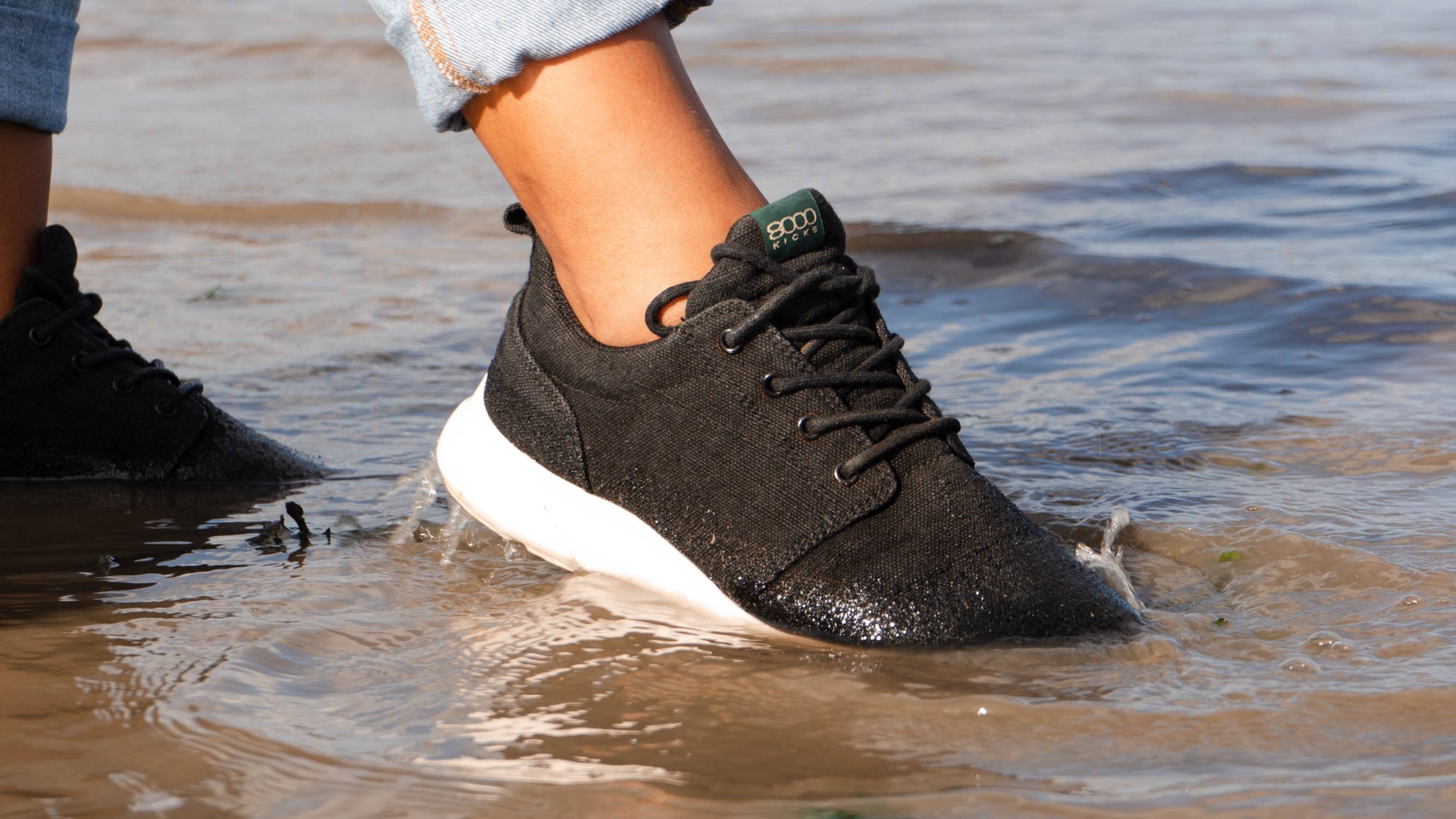 person standing in water with their water repellant sustainable shoes