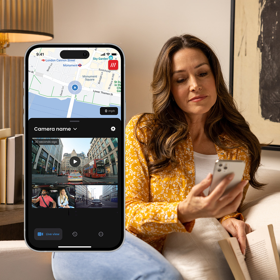 Woman using a smartphone with a map and video interface displayed.