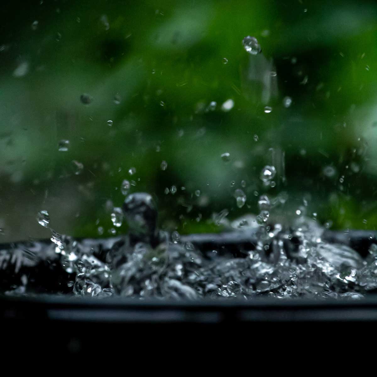 Water droplets bouncing off a water barrel