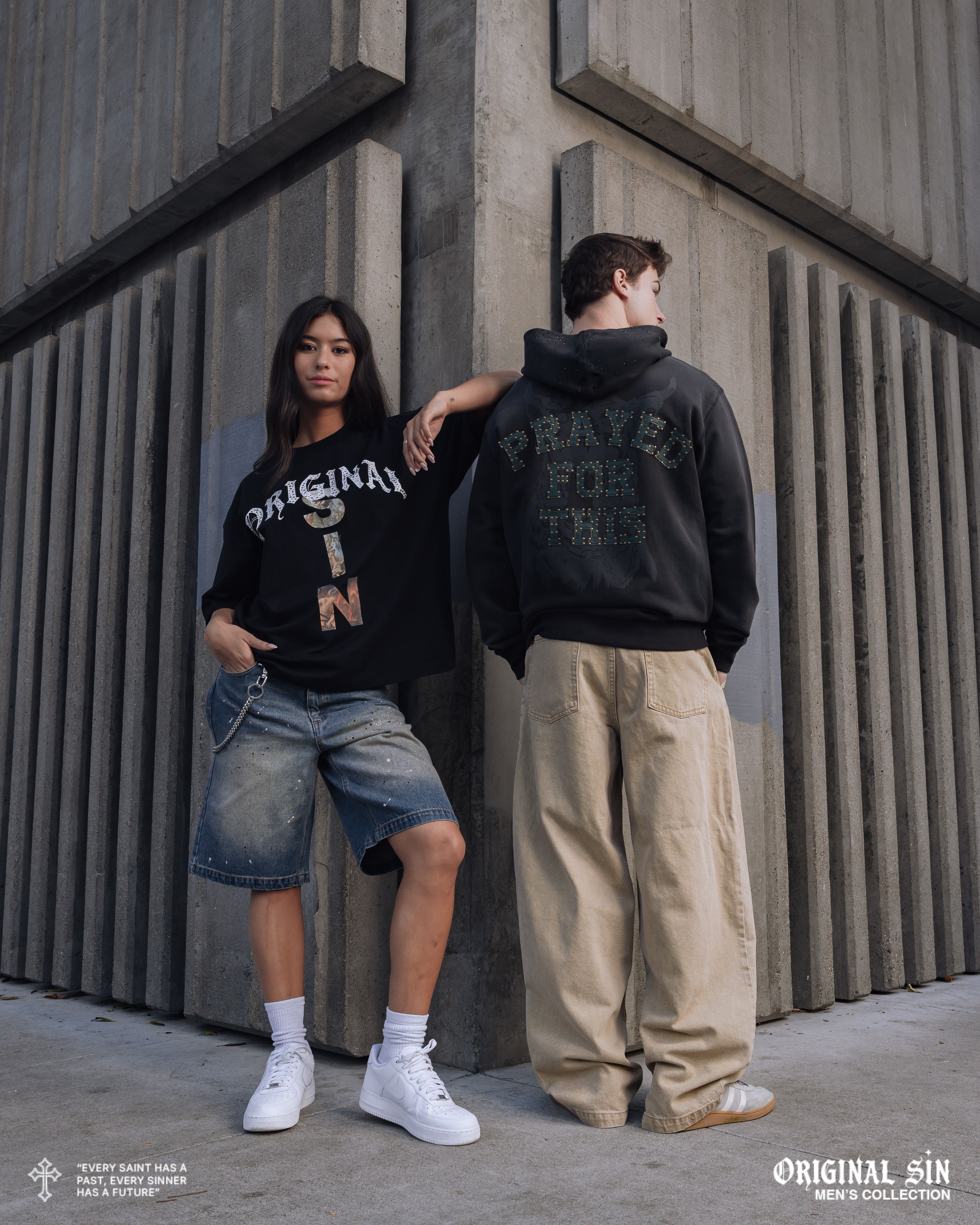 Two models posing in streetwear against a textured wall.