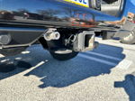 Close-up of rear bumper quick-connect air fitting mounted next to trailer hitch on black truck
