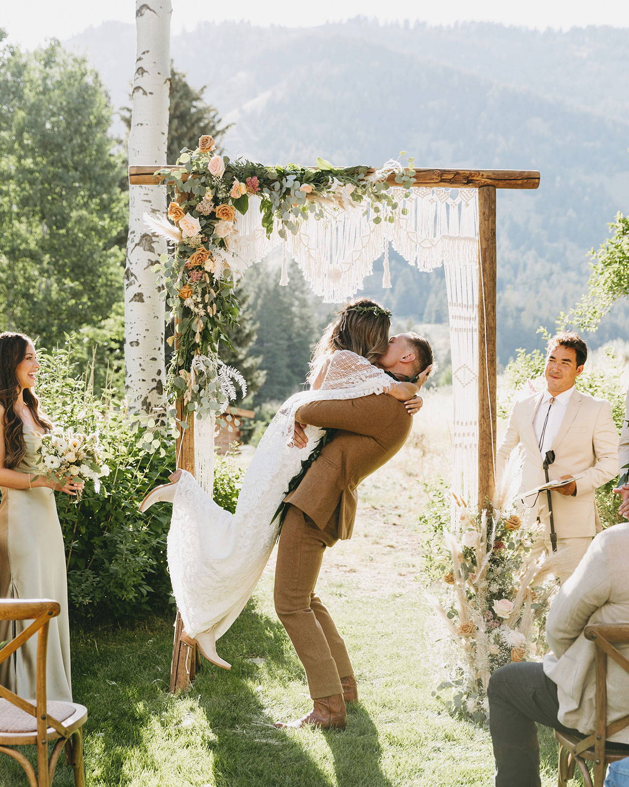 Groom holding bride up in the air at the altar