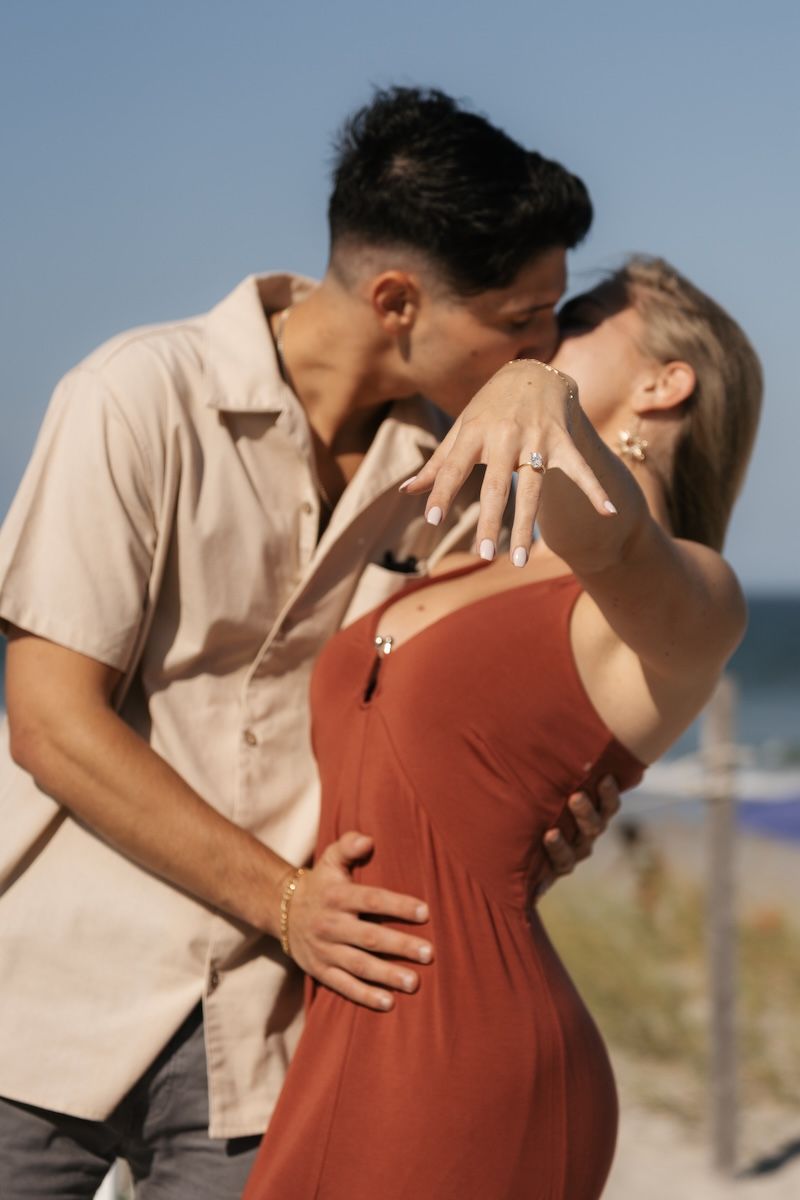engaged couple kissing on wrightsville beach, nc