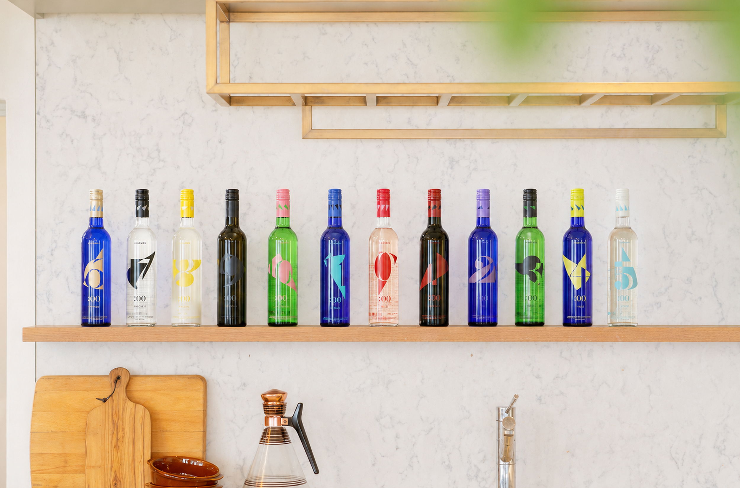 A shelf displaying various colorful liquor bottles in a kitchen setting.