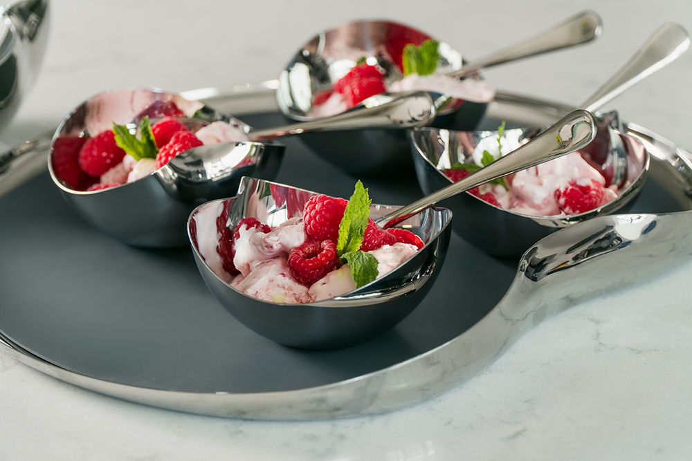 Four Drift bowls of ice cream with raspberries on a Drift tray.