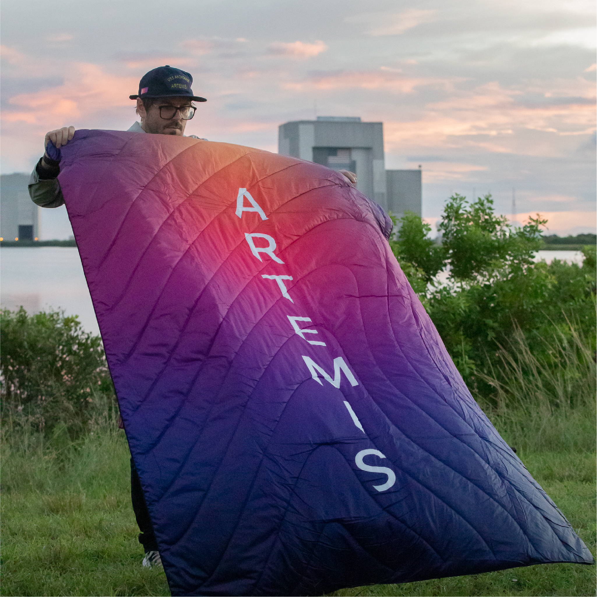 Man standing near takeoff with a Rumpl NASA Artemis Blanket