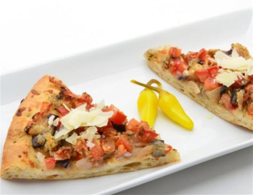 Two slices of pizza on a white plate with yellow peppers.