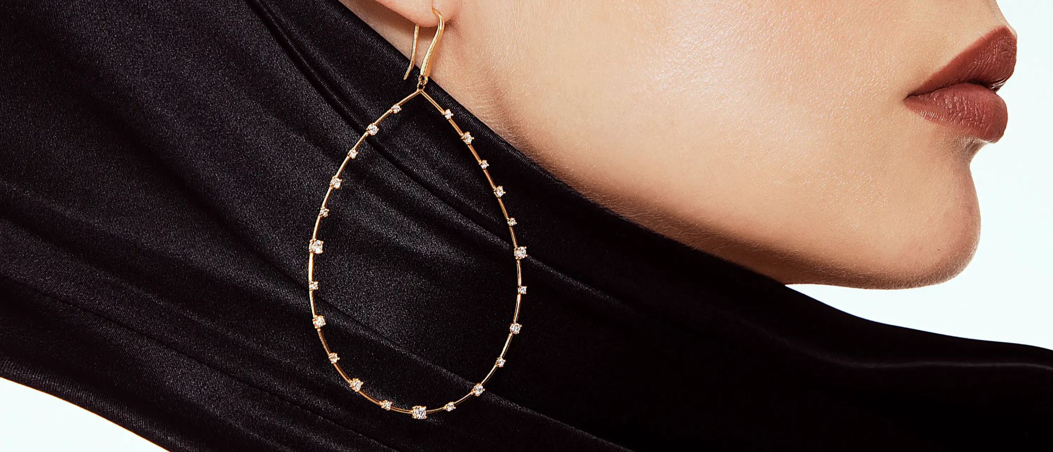 Close-up of a woman's ear adorned with large hoop earrings.