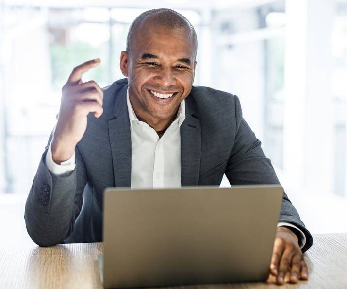 Man smiling while looking at laptop