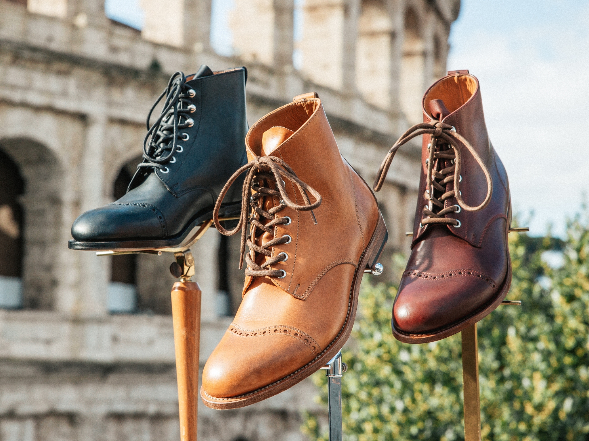 Three pairs of stylish leather boots displayed outdoors.