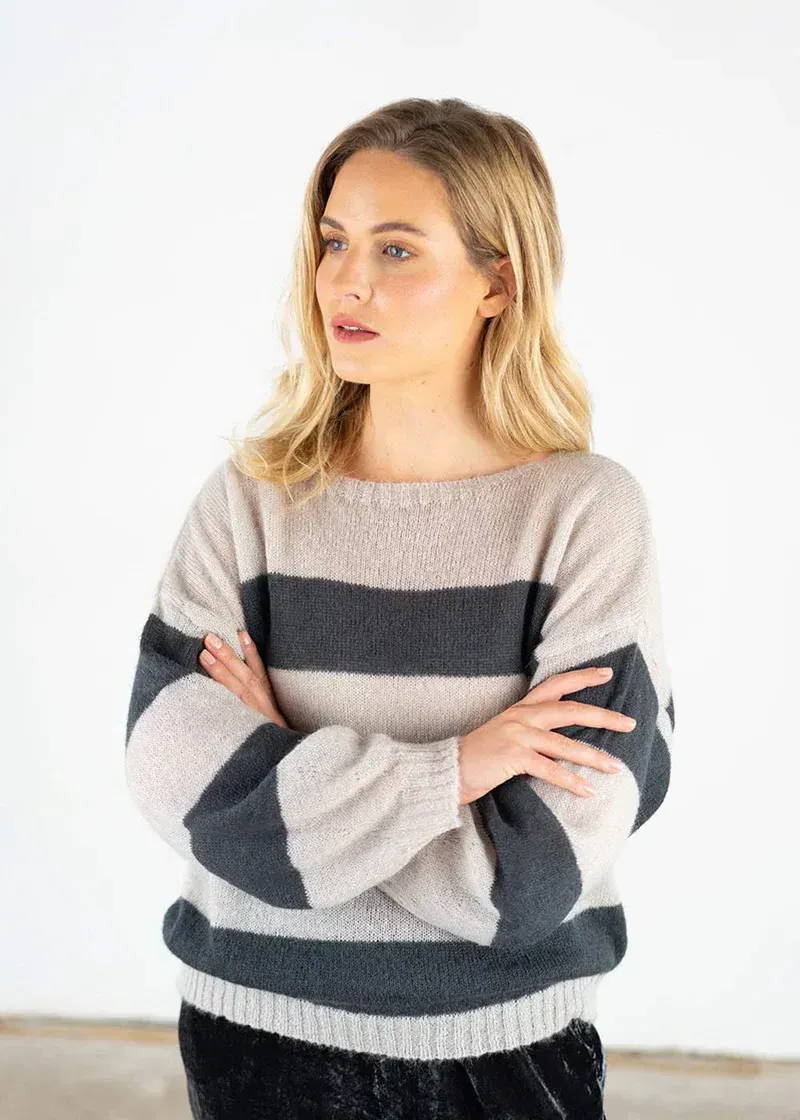 Model wearing a oatmeal and grey striped jumper