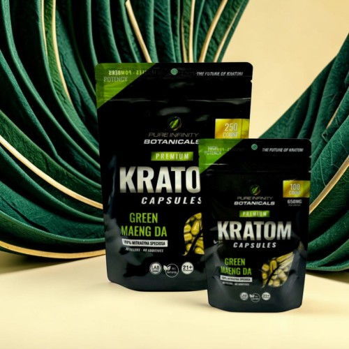 Kratom capsules in packaging with green plant background.