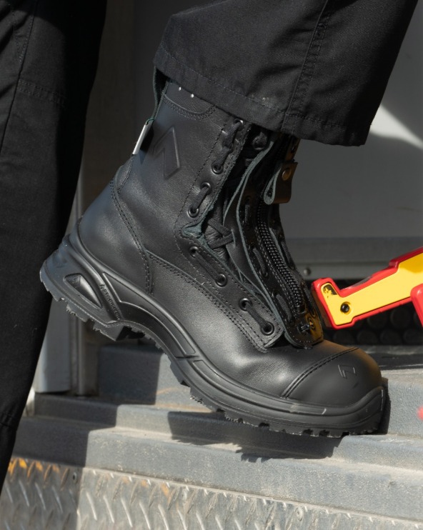 A black tactical boot stepping onto a metal surface.