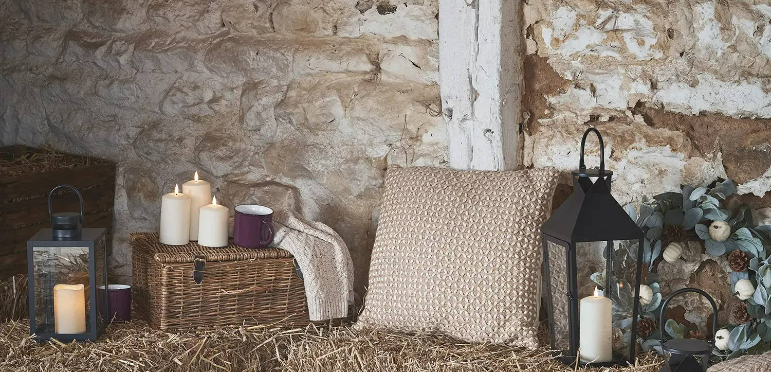 A cosy autumn setting in an outdoor barn with festoons, candles and lanterns.