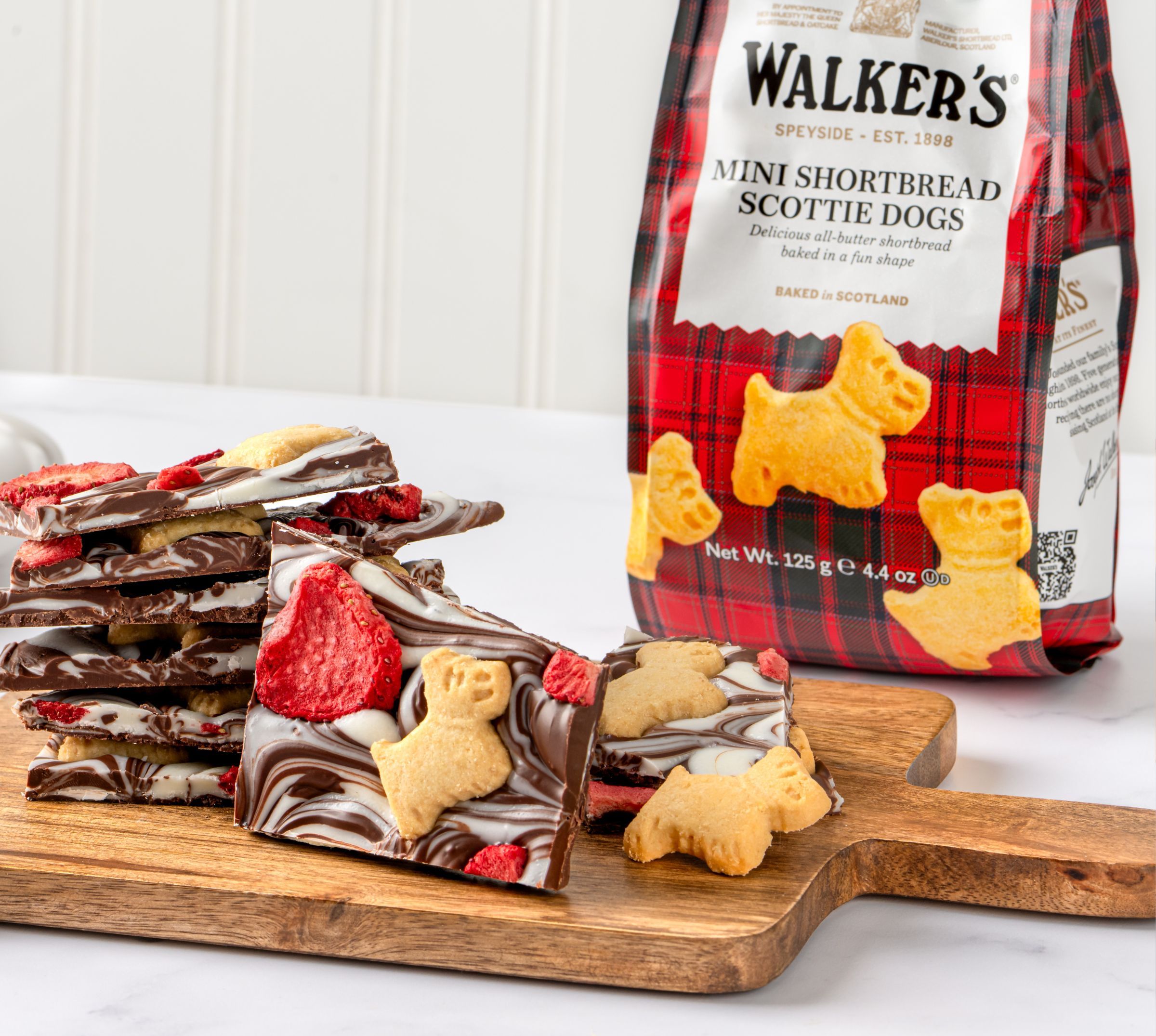 Chocolate Bark on a wooden board with a bag of Walker's mini scotties