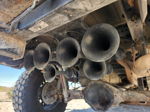Five-trumpet train horn kit mounted beneath truck bed on lifted Dodge Ram undercarriage