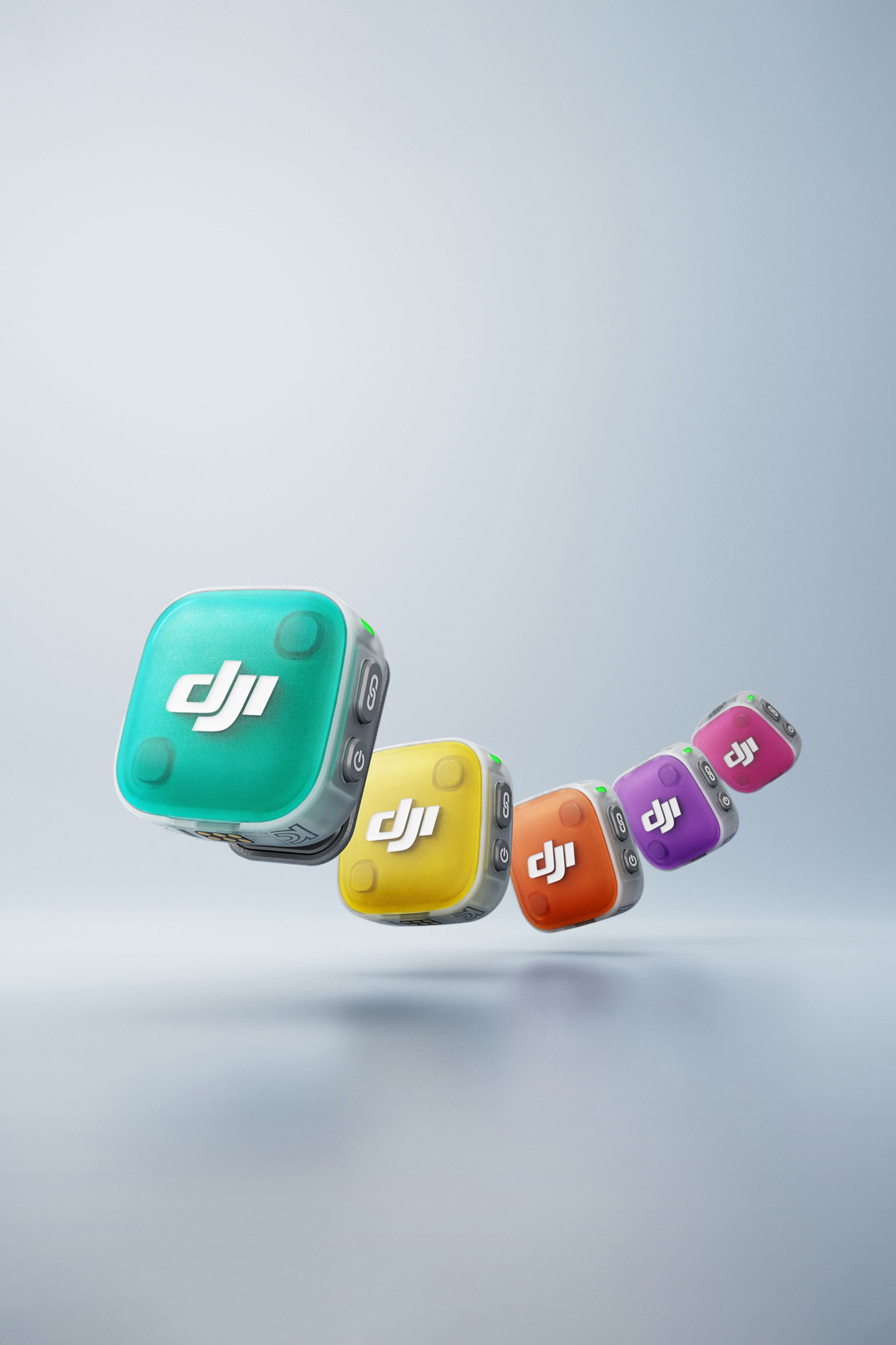 Colourful faceplates in green, yellow, orange, purple, and pink on the DJI Mic Mini 2 against a grey background