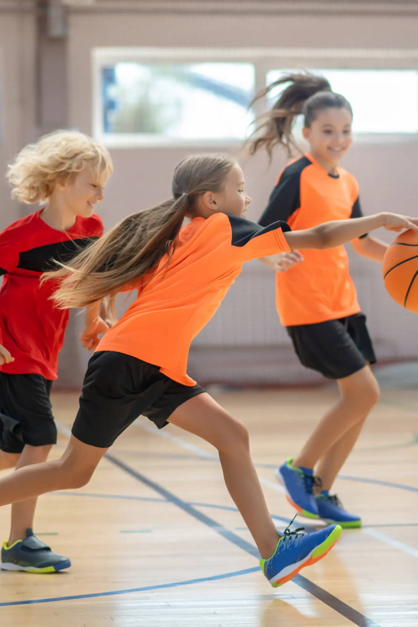 Kids playing basketball in gymnasium