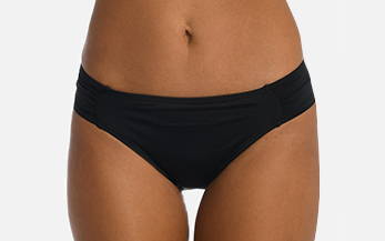 Front image, close-up of model wearing black side shirred hipster swimsuit bottoms.