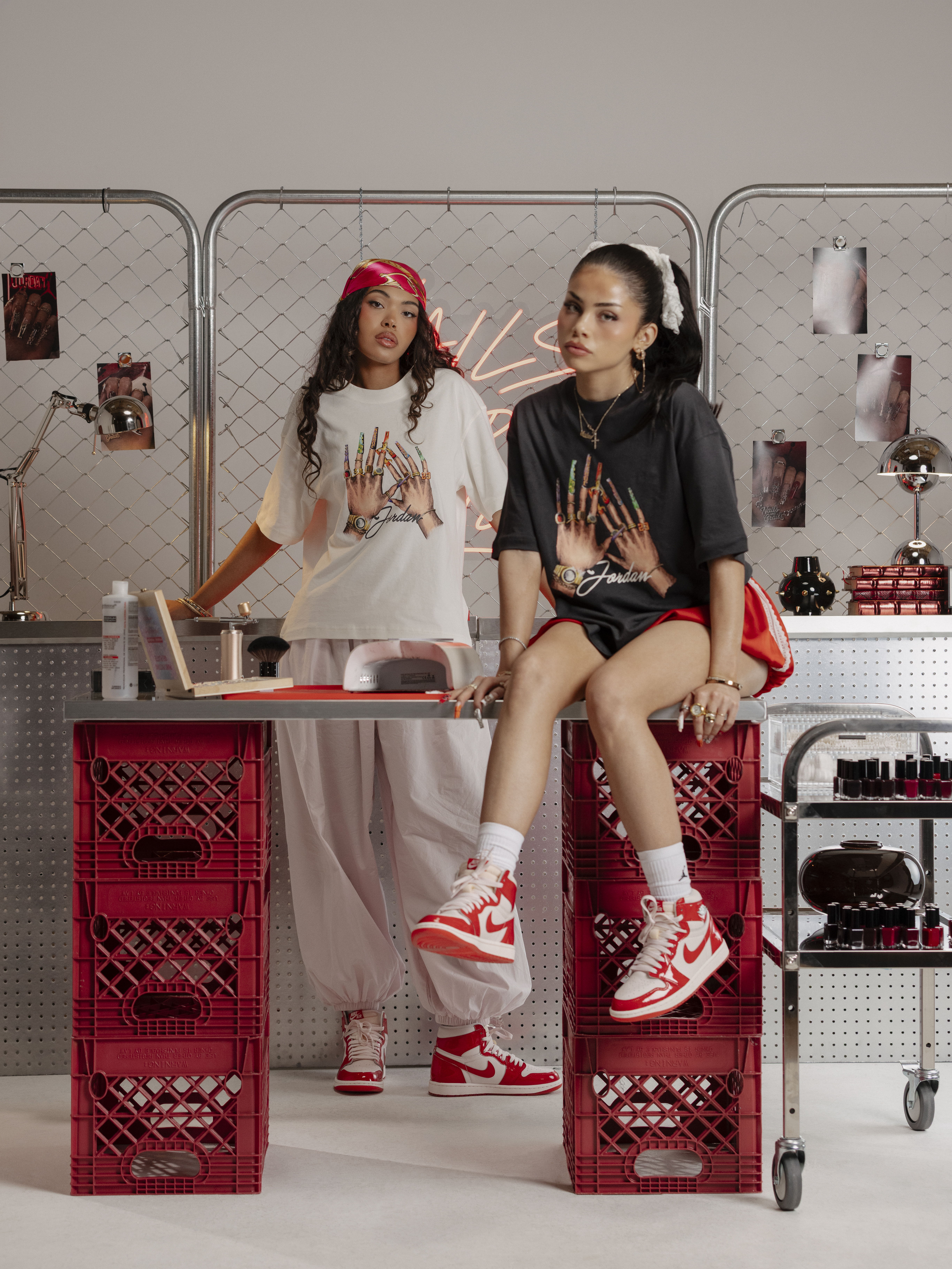 Two women in stylish outfits pose in a creative space.