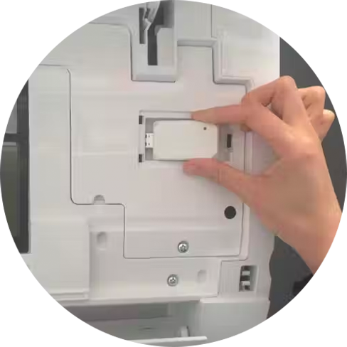 person's hand plugging in a USB wifi module into a ductless air unit