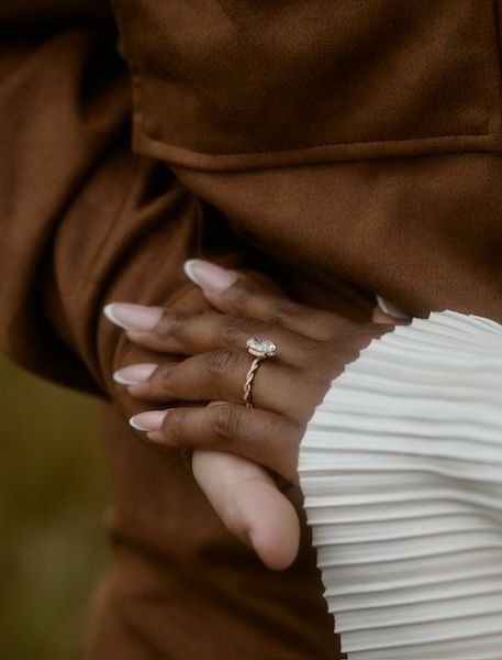close up of oval engagement ring on hand