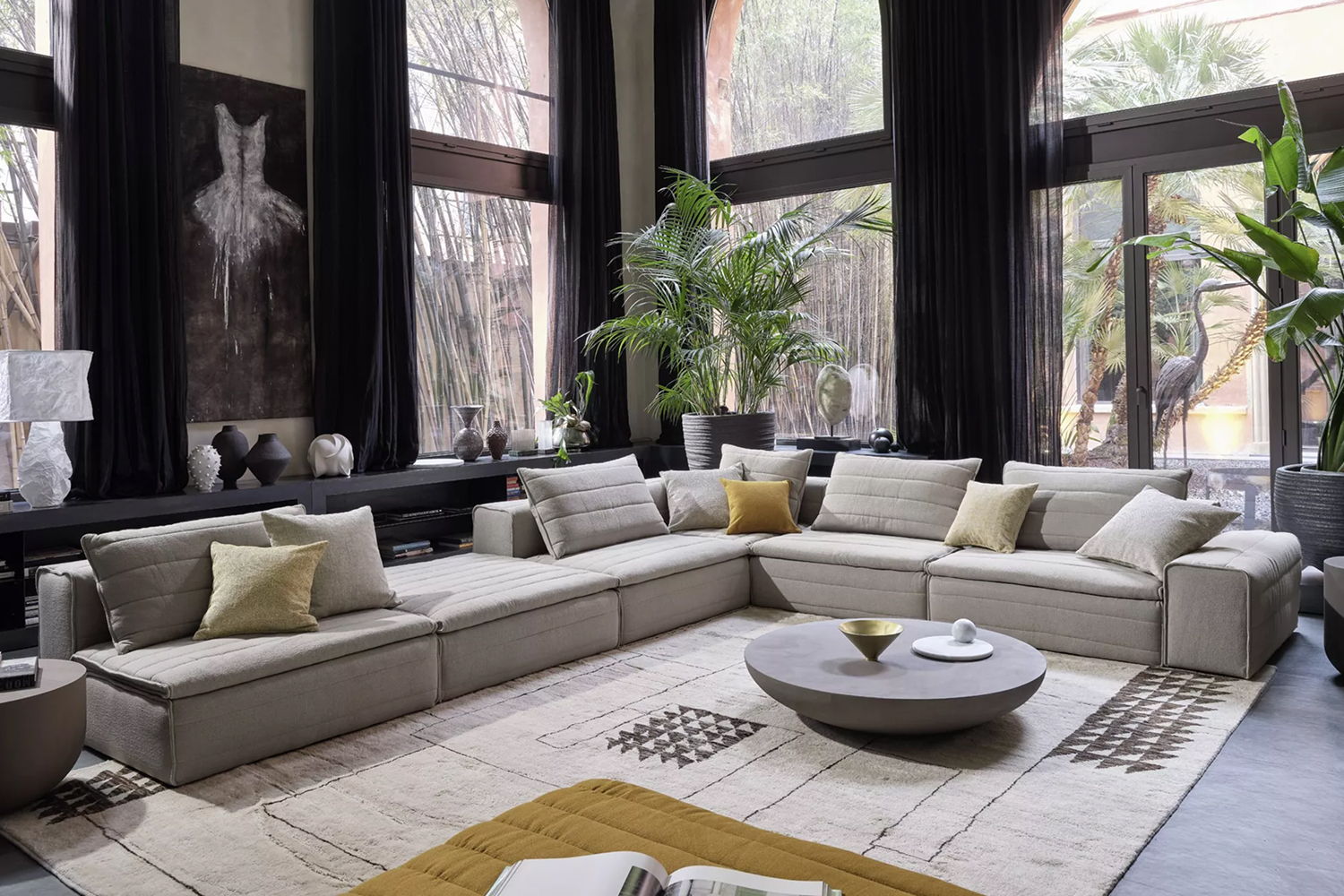 Modern living room with a sectional sofa, coffee table, and plants.