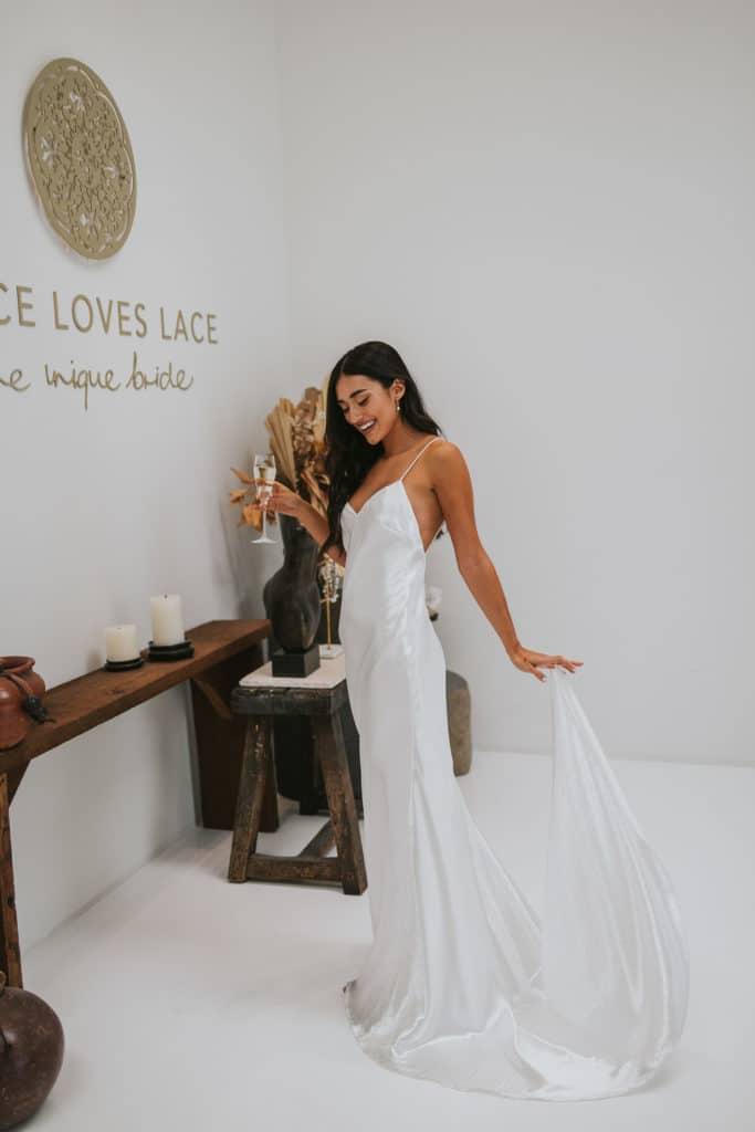 Bride wearing the Oceania silk dress inside the Grace Loves Lace Dallas showroom