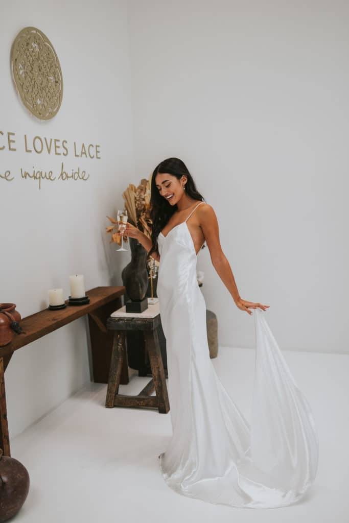 La mariée portant la robe en soie Oceania dans le showroom de Grace Loves Lace à Dallas.