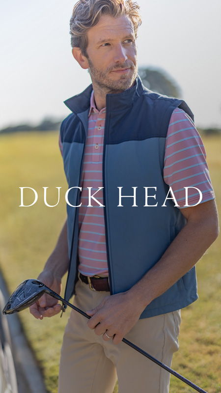 A man in a vest holding a golf club, standing outdoors.