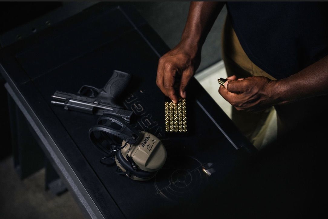 man loading firearm magazine
