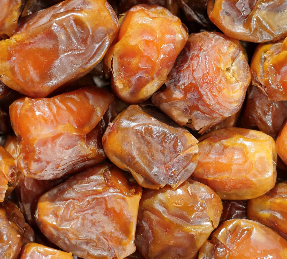 A close-up of various dried dates piled together.