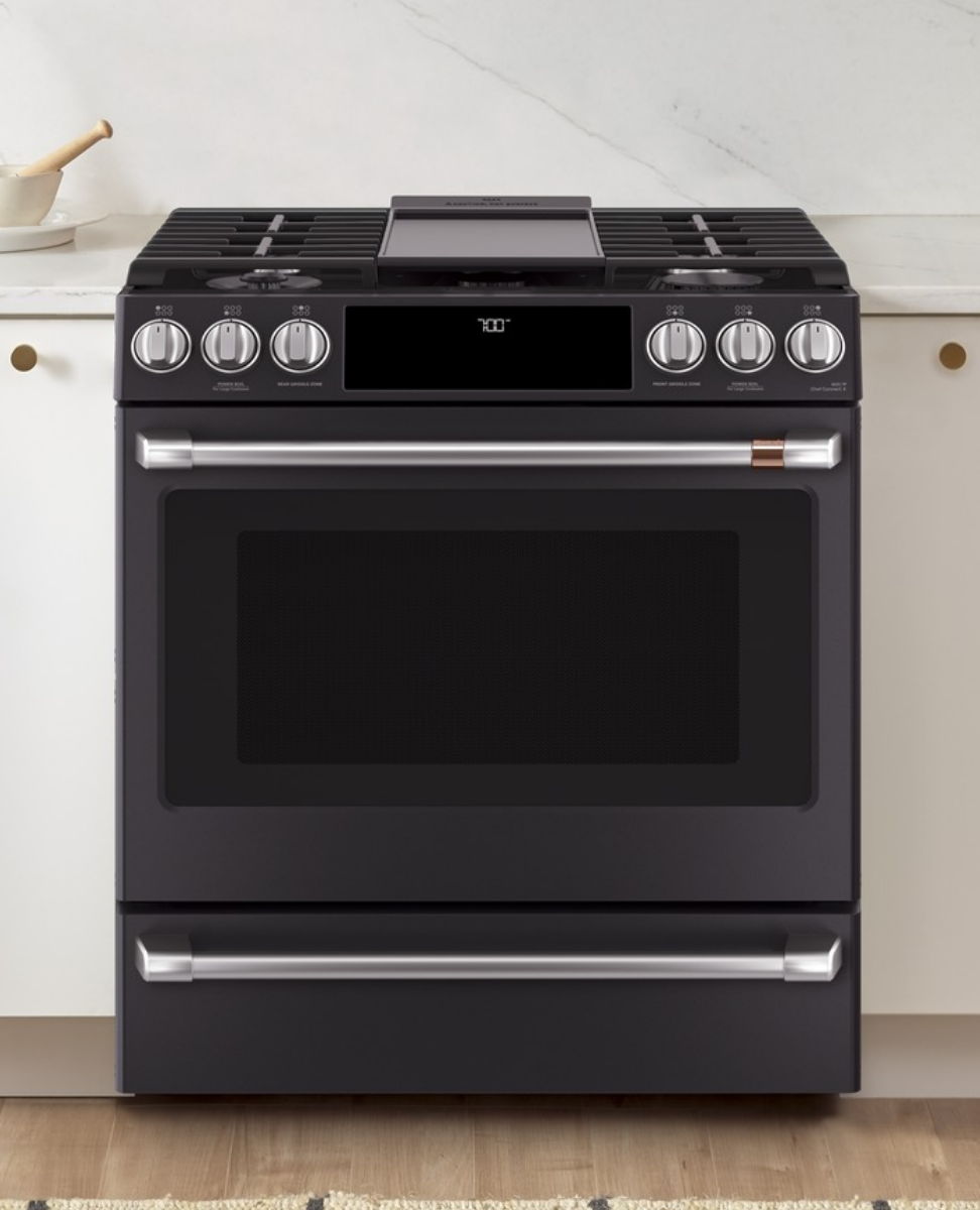 A modern black gas stove with an oven and control knobs.