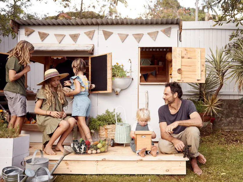 A flat roof cubby house with a family