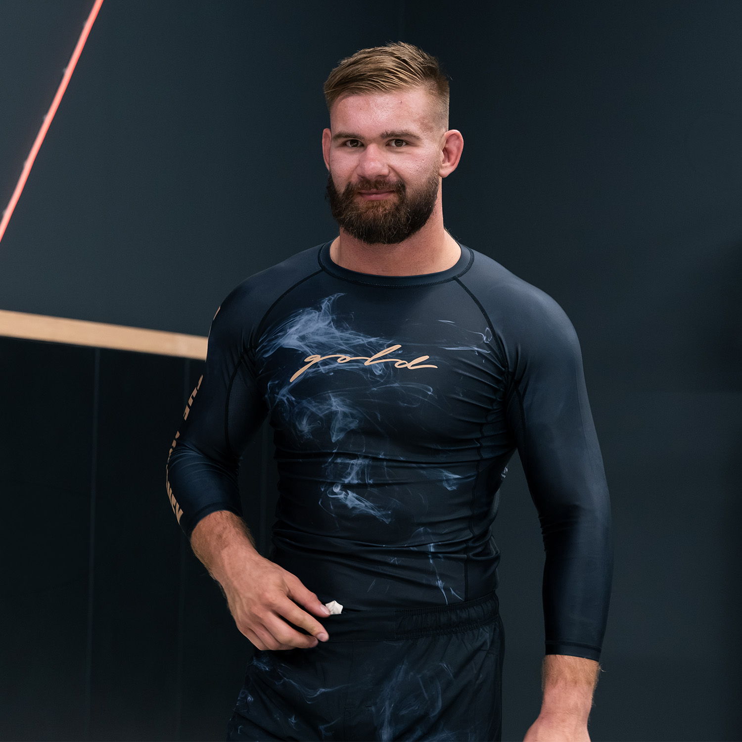 Athlete in a fitted black shirt, posing confidently.