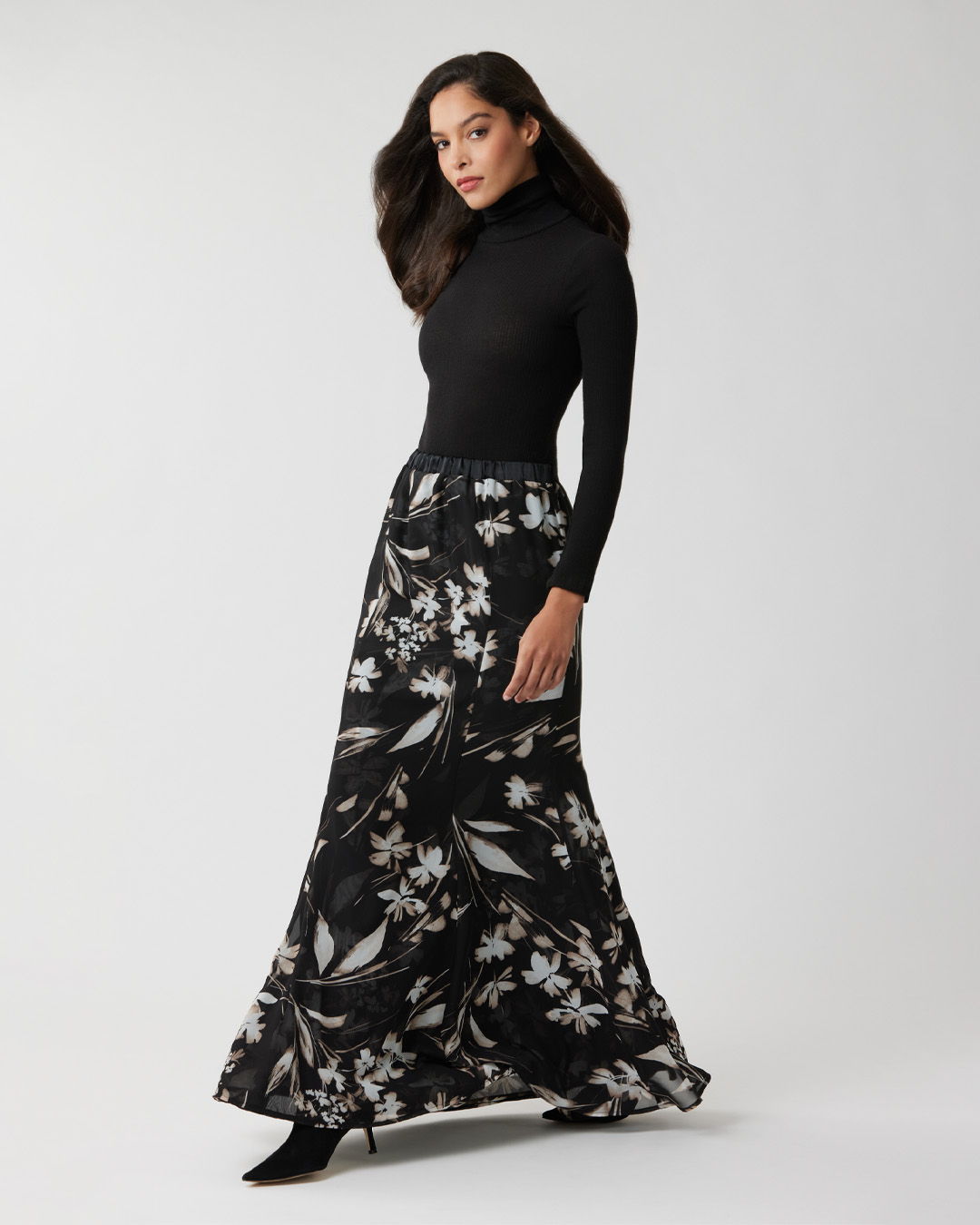 Model wearing a black turtleneck and a floral maxi skirt.