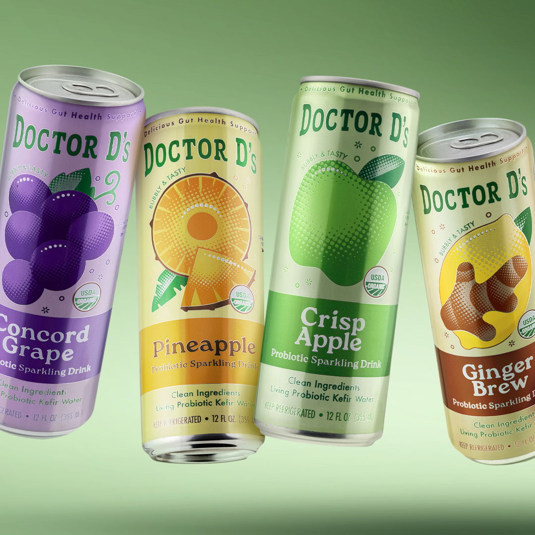 Four cans of Doctor D beverages: grape, pineapple, crisp apple, and ginger brew.