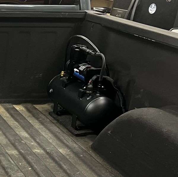 Black air tank and compressor mounted inside the bed of Kevin's 2007 Chevrolet Silverado Classic 2500HD, install photo 4