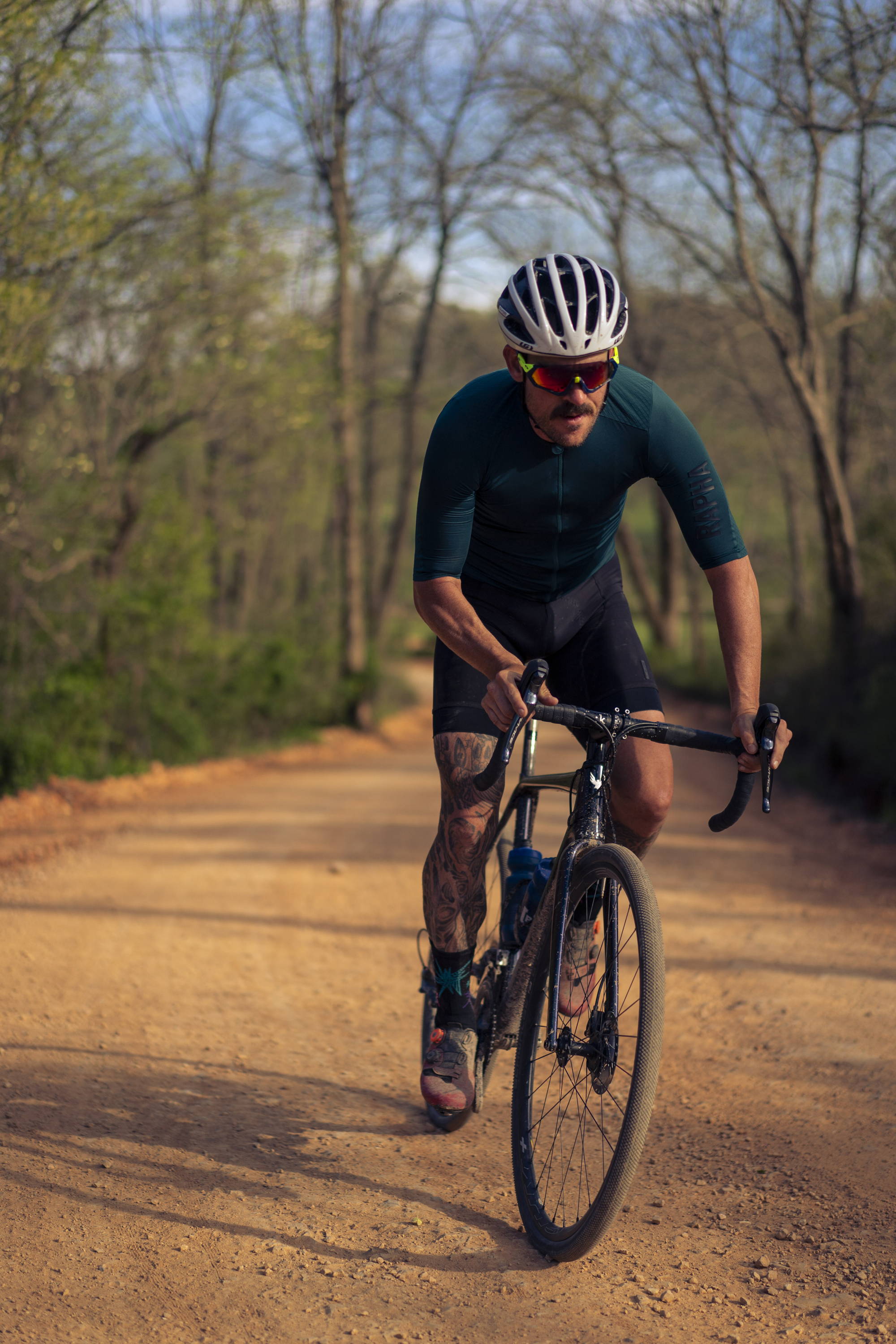 A cyclist riding his bike down a country dirt road