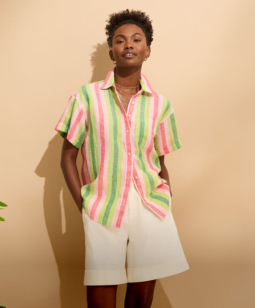 Person in a colorful striped shirt and white shorts against a neutral background.