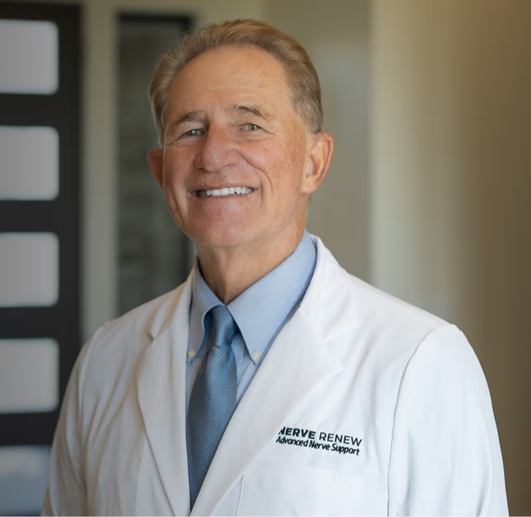 Smiling doctor in a white coat standing in a clinic.