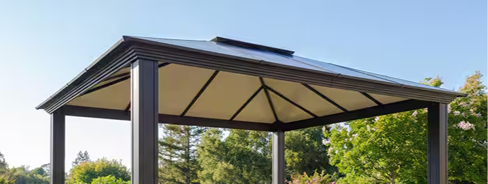 A gazebo with seating and a dog in a garden setting.